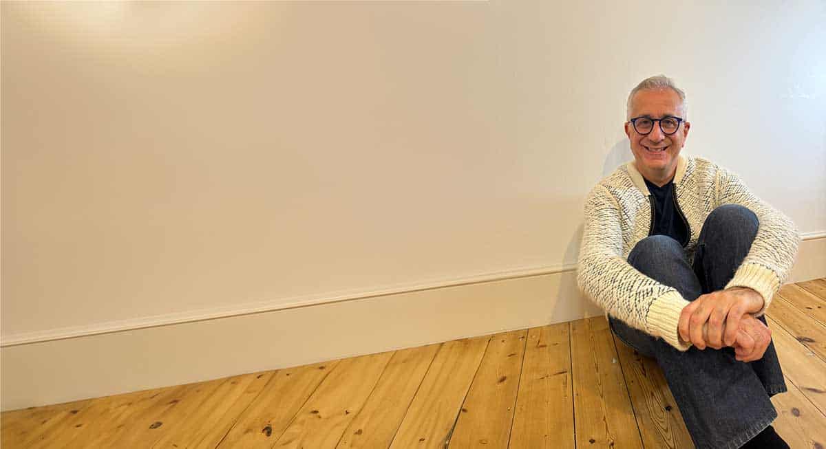 Anthony Basker sitting on wood floor